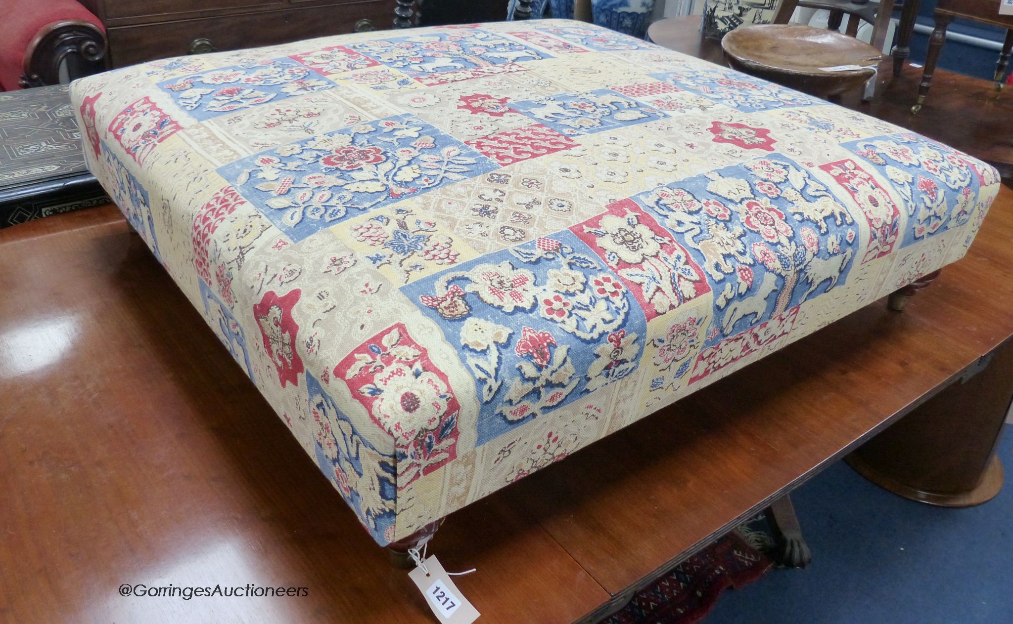 A Victorian style upholstered footstool in Andrew Martin fabric. W-103, D-95, H-28cm.